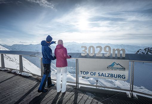 Zwei Personen stehen auf der Aussichtsplattform „Top of Salzburg“ auf 3.029 Metern mit Blick auf das Bergpanorama.