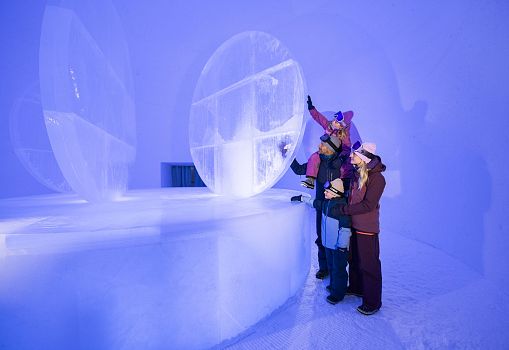 People exploring an igloo with an ice bar.