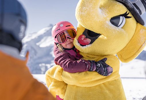 Our yellow elephant mascot is hugging a girl.