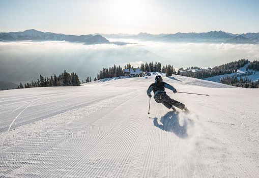 A skier glides gracefully down the freshly prepared slopes of Schmittenhöhe in Zell am See.