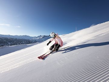 Eine Skifahrerin fährt über eine frisch präparierte Piste in Rauris.